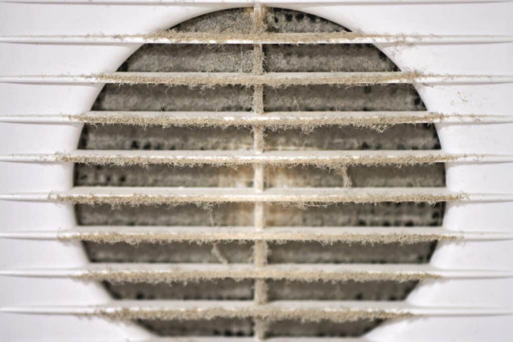 extremely dirty air ventilation grill hvac with dusty clogged filter close up