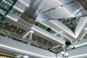 large multistorey shopping center with escalators elevators view interior airport with ornamental plants large lamps
